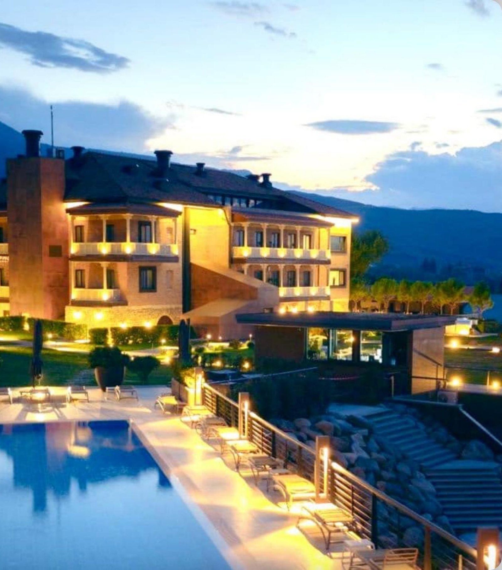 Luxury resort with illuminated pool at dusk